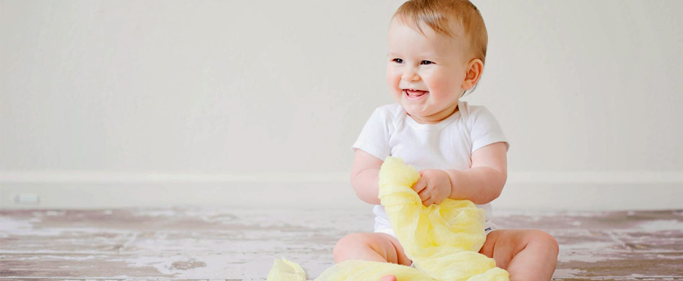 Baby sitting on the floor playing.