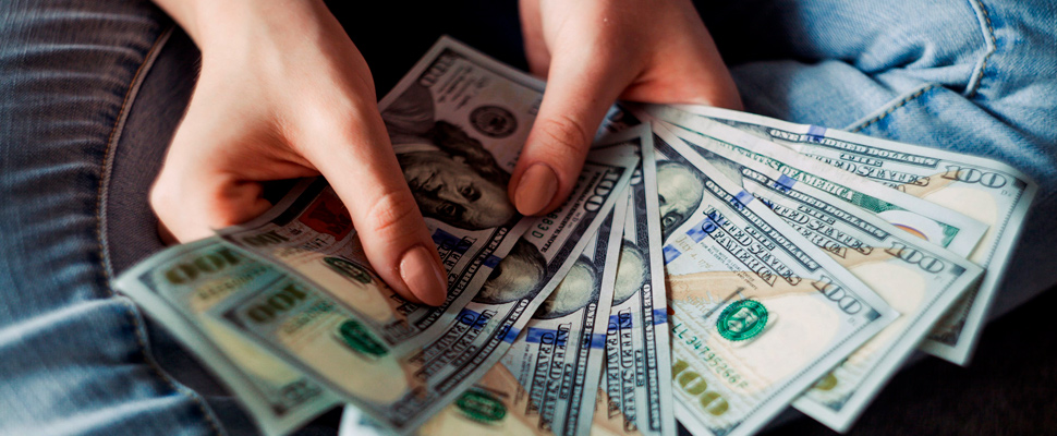 Person holding 100 us dollar banknotes