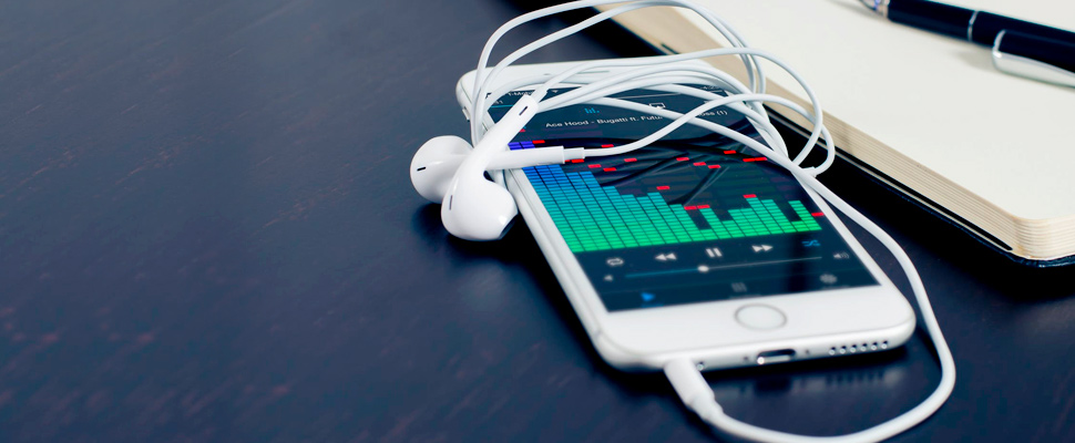 Cell phone on a table with rolled headphones