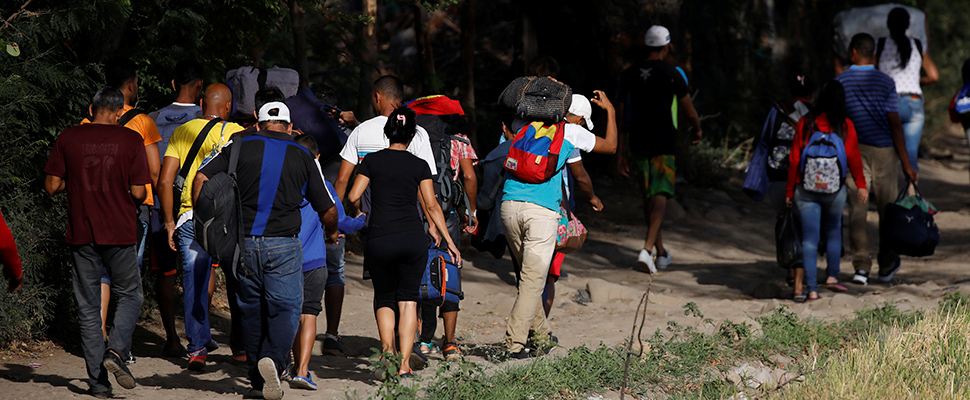 Venezuelans take their belongings on an illegal road after entering Colombia illegally