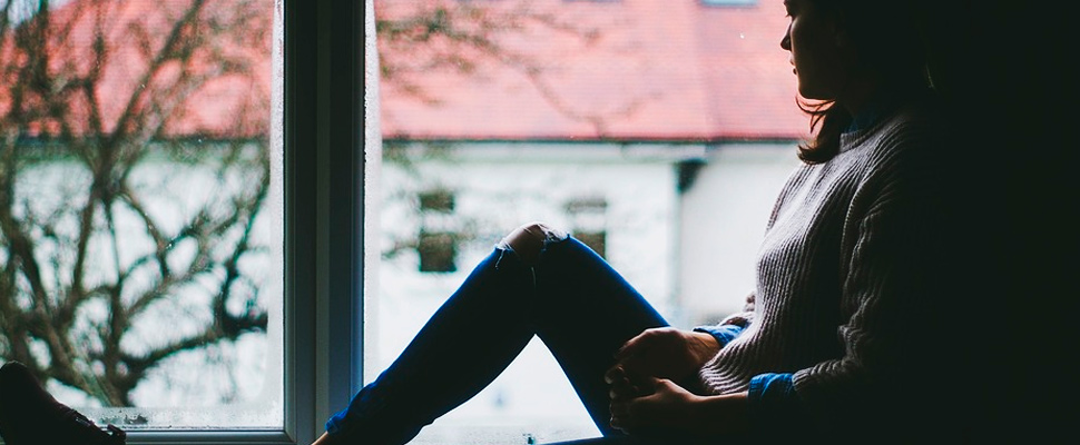 Woman sitting watching through a window.