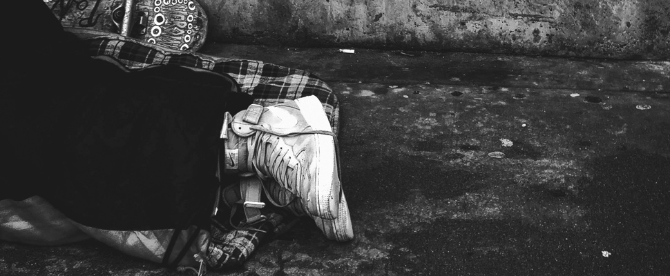 Feet of a person lying on the street floor.