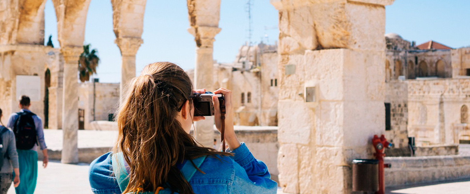 Woman taking pictures of ruins.