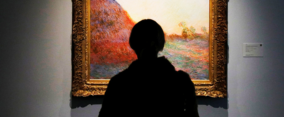 Person watching a painting in a museum.