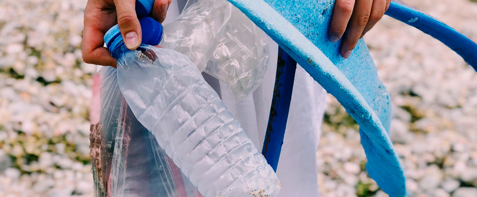 Person holding plastic bottles.