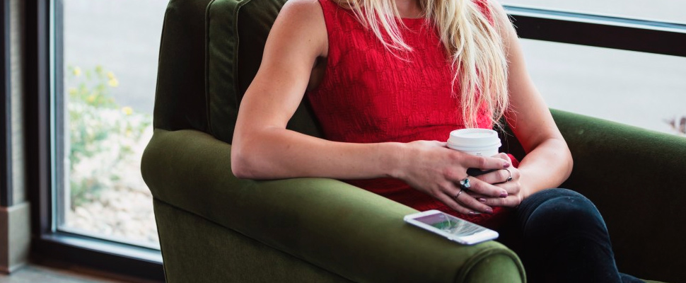 Woman sitting holding a glass of coffee