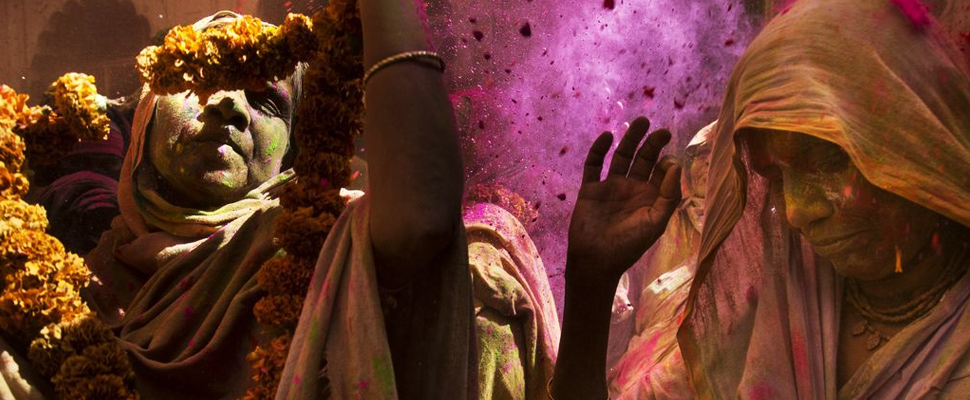 Women participate in the Holi ceremony at the Gopinath Temple in India