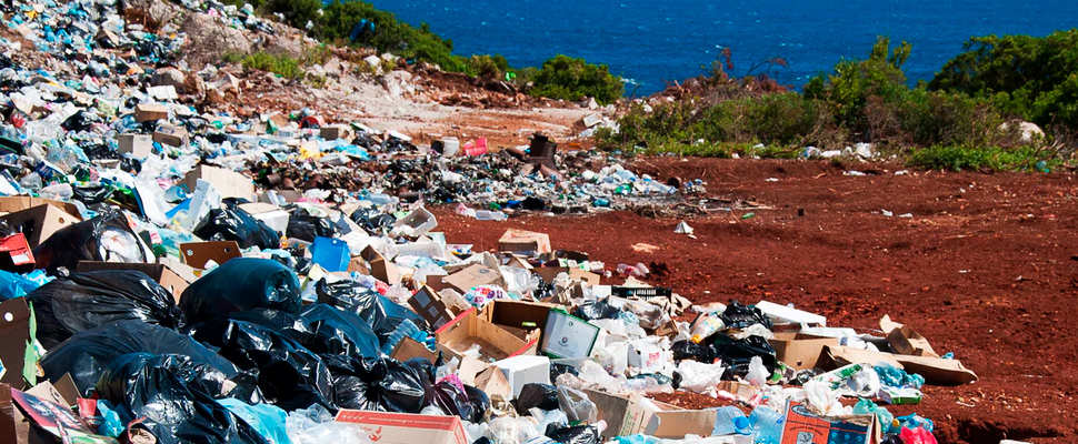 Mountain of garbage on the beach by the sea.