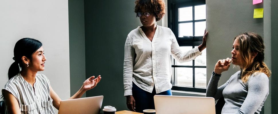 Three women in a meeting.