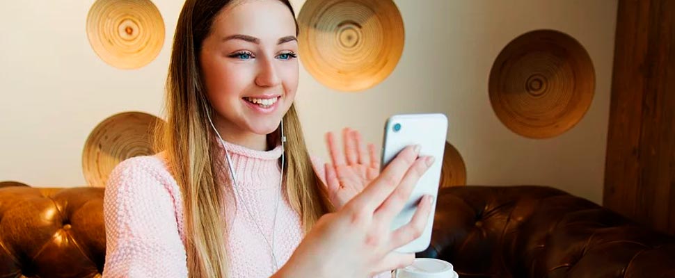 Girl holding her cell phone making a video call.