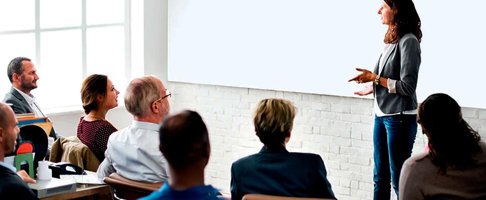 Woman giving a talk to a group of people.