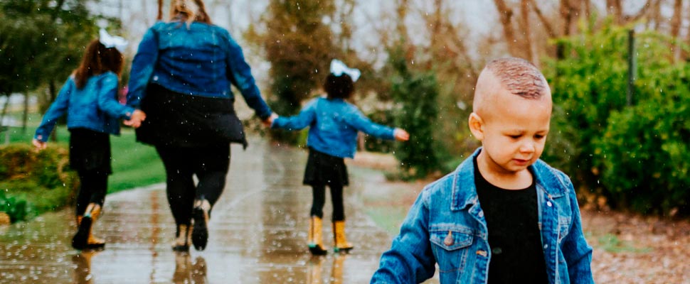 Boy walking on a wet trail.