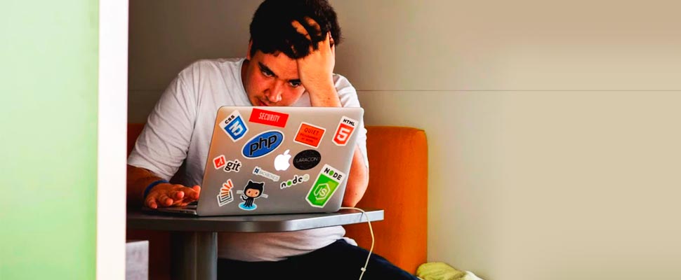 Man using a laptop looking stressed.