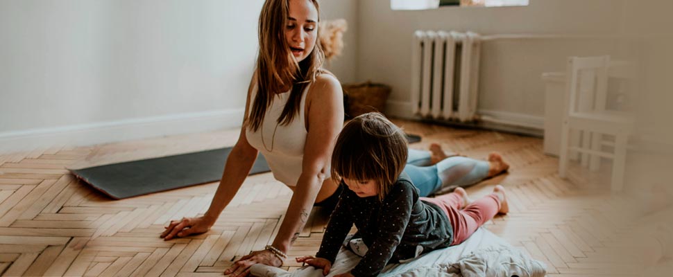 Woman practicing yoga with her little daughter