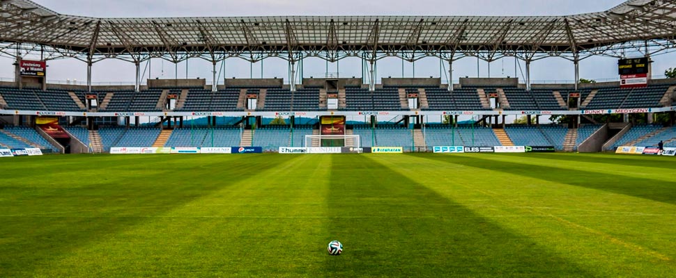 Soccer ball in the middle of an empty stadium.