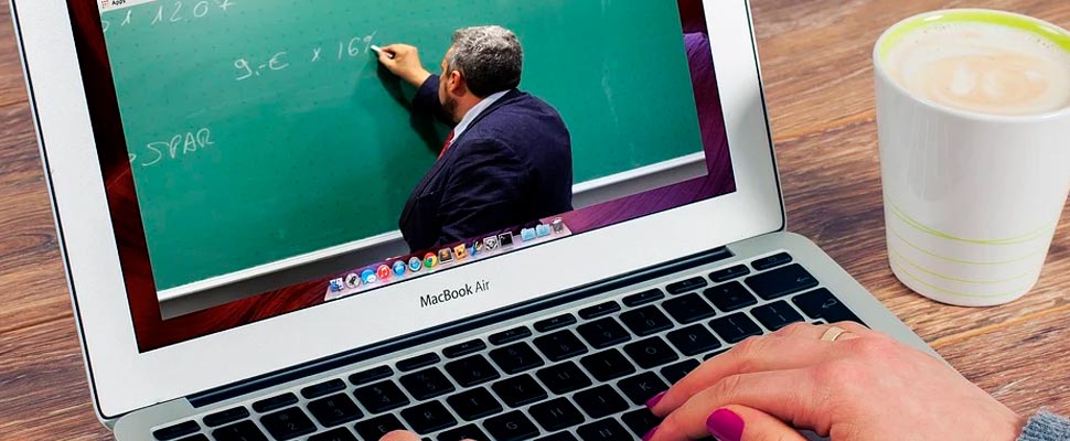 Woman watching a virtual class through her computer.