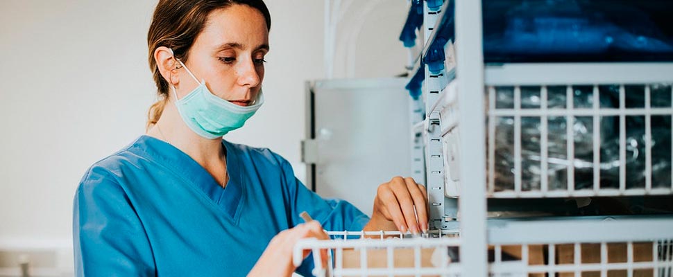 Nurse searching for medications in a drawer.