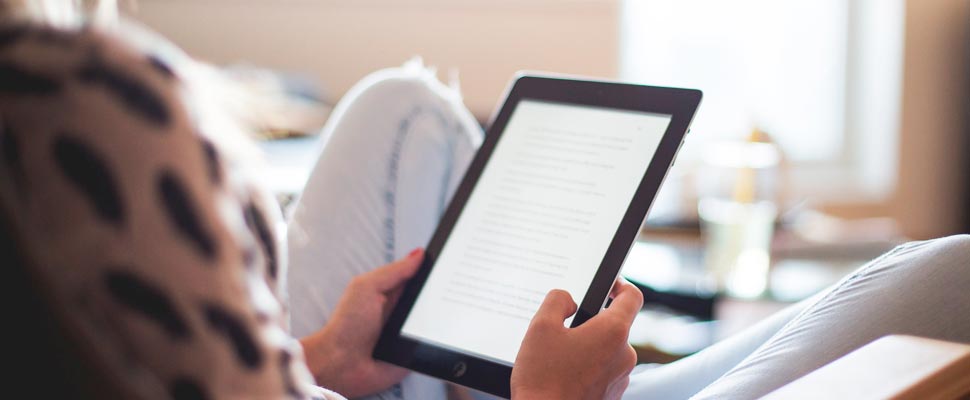 Woman reading a book from her Kindle.