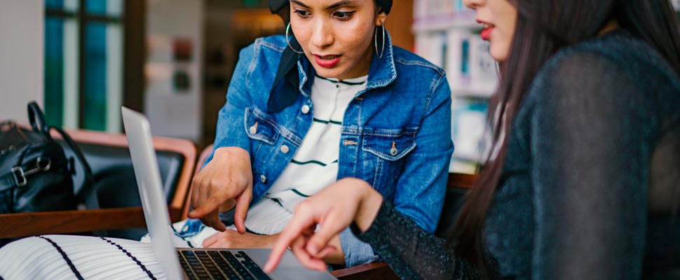 Two women working with a computer.