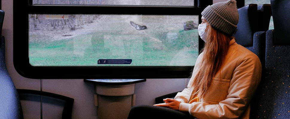 Woman wearing a mask while traveling by train.