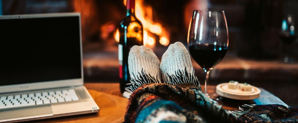 Person with a bottle and glasses of wine by his side