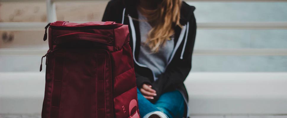 Woman sitting next to a travel suitcase