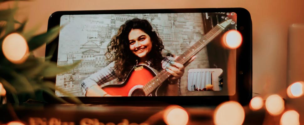 Person making video call holding a guitar