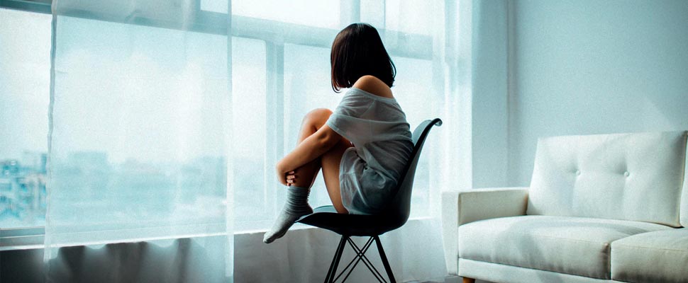 Woman sitting on a chair looking out a window