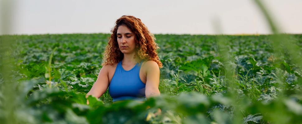 Woman meditating while sitting in a field