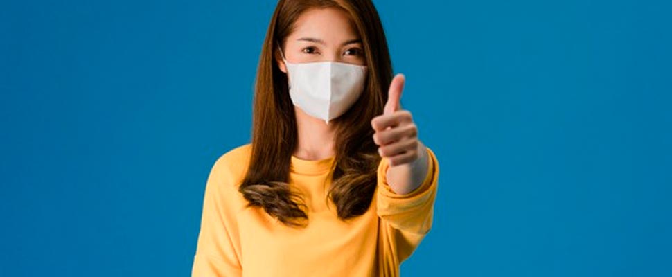 Woman wearing mask showing thumb up