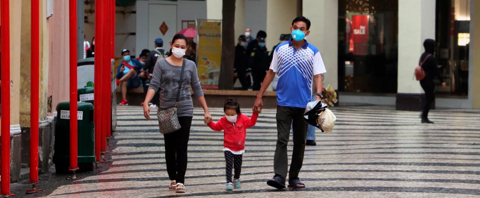 Family walking down the street wearing face masks