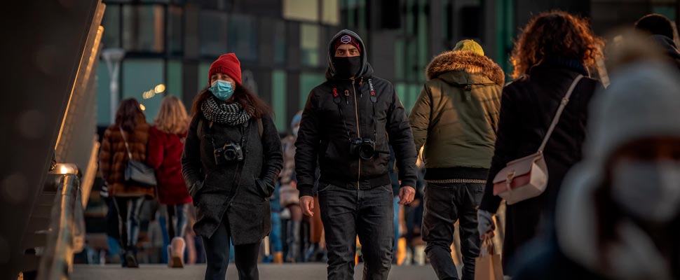 People walking in a street wearing face masks