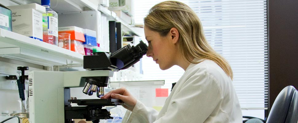 Woman inside laboratory holding a plate