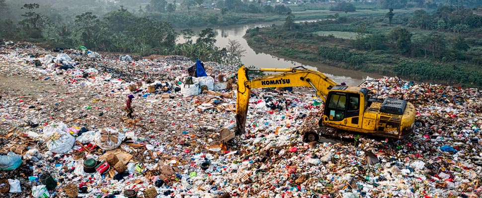 Excavator on a mountain of garbage