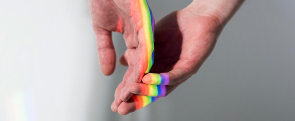 Two hands with the LGBT flag