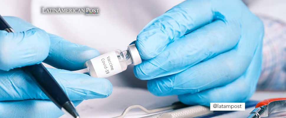 Health personnel holding a vial of a vaccine