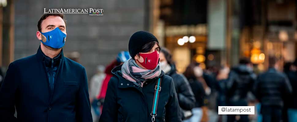 Couple walking down a street while wearing face masks