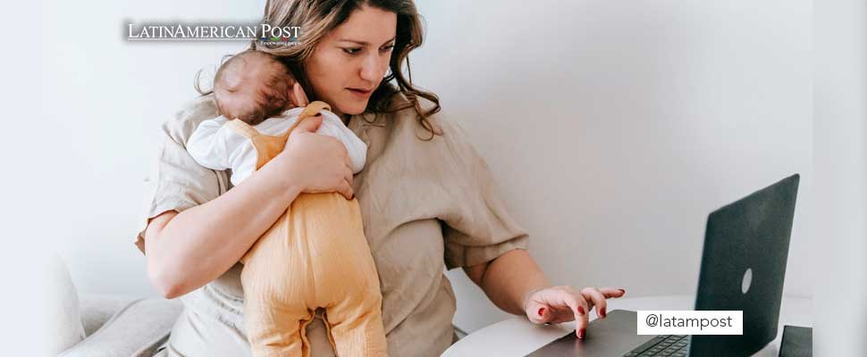 Woman working from home carrying her baby