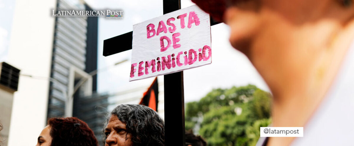 Woman holds a sign that says 'Enough Femicide'