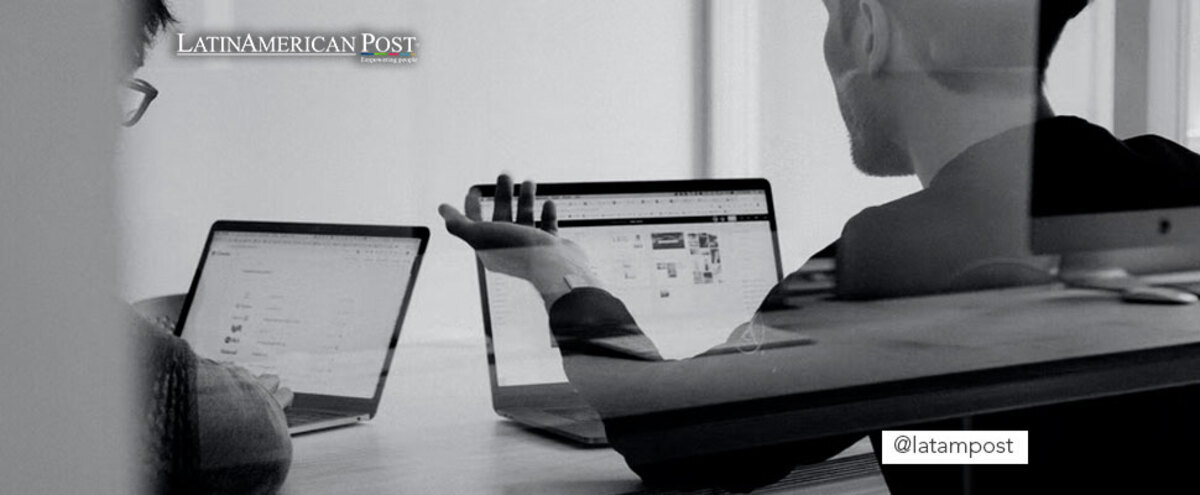 Men using two computers in an office