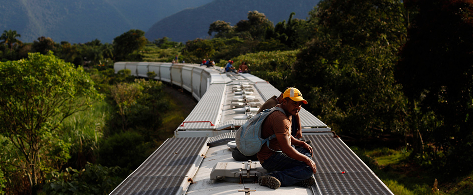 Honduran immigrants travel on top of a freight train on their way to the United States border in La Patrona