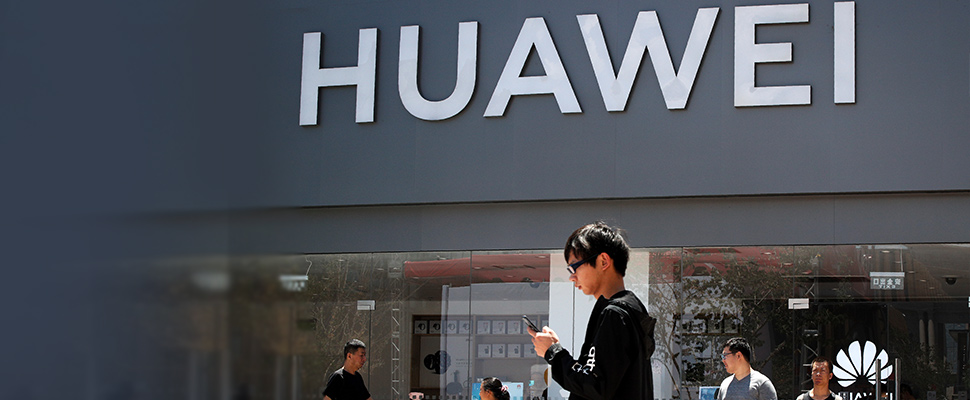 People walk past a Huawei retail store in Beijing