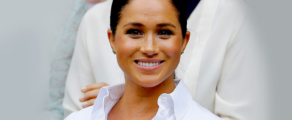 Meghan Markle, Duchess of Sussex smiles while sitting in the Royal Box on Centre Court on at the Wimbledon Tennis Championships in London.