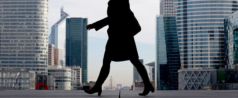 A Businesswoman is silhouetted as she makes her way under the Arche de la Defense, in the financial district west of Paris